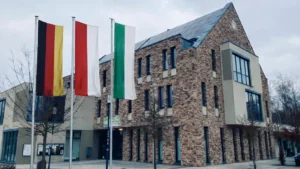 KI-Montage: Schulzendorfer Rathaus mit drei Fahnenmasten
